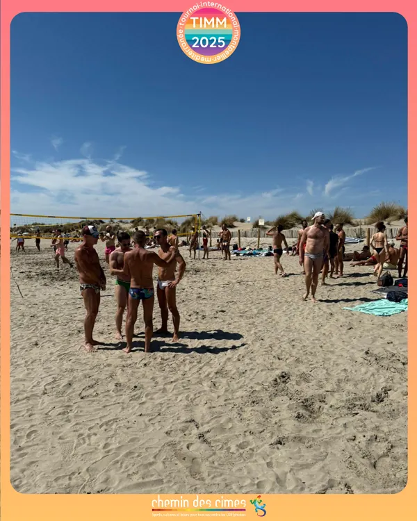 Un groupe profite de la plage le dimanche, avec un filet de volley en arrière-plan.